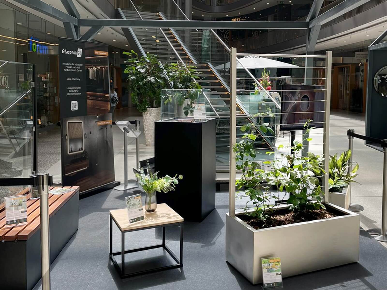 Ausstellung Glasprofi24 im stilwerk Düsseldorf mit Pflanzkasten, Gartenbank und Feuersäule