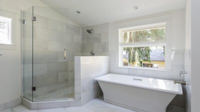 Große Eckdusche mit einer Tür neben großer Wanne