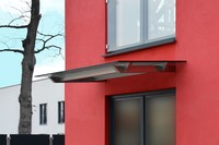 Design Vordach Skala an roter Fassade
