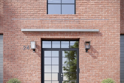 Freitragendes Glasvordach an Hausfassade aus rotem Klinker