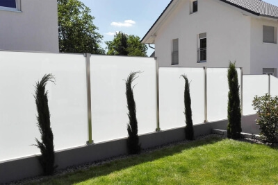 Glaszaun im Garten montiert auf einer Erhöhung mit Schrägschnitt