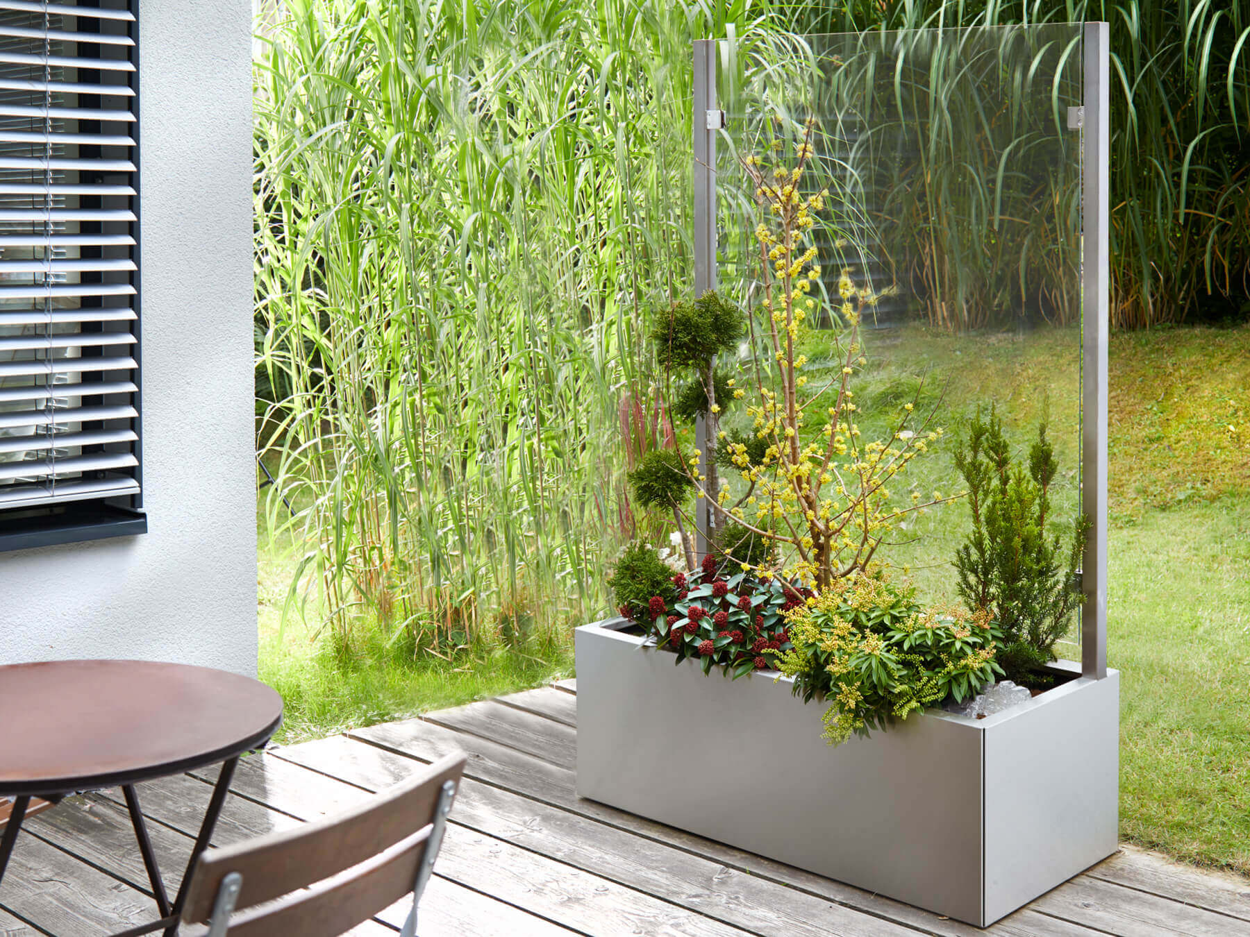 Bepflanzter Pflanzkasten mit Wind- und Sichtschutz auf Terrasse